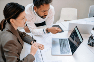 A guy showing a colleague something on the laptop